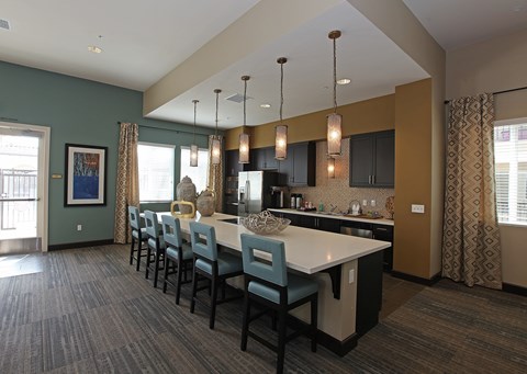 A kitchen with a long table and chairs.