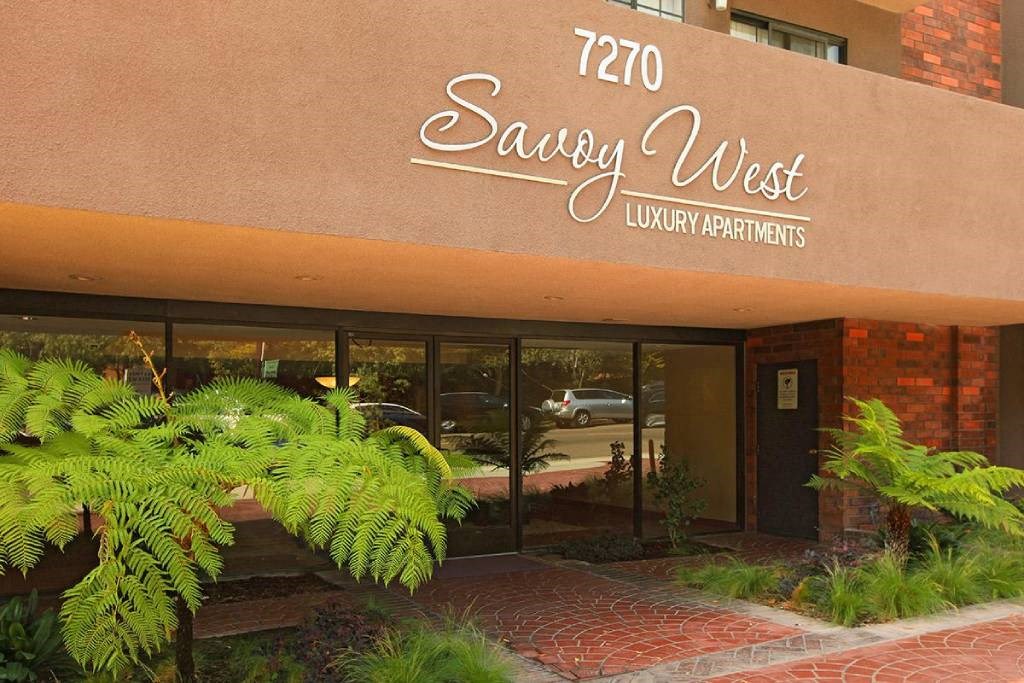 a building with a sign for the savoy west library apartments