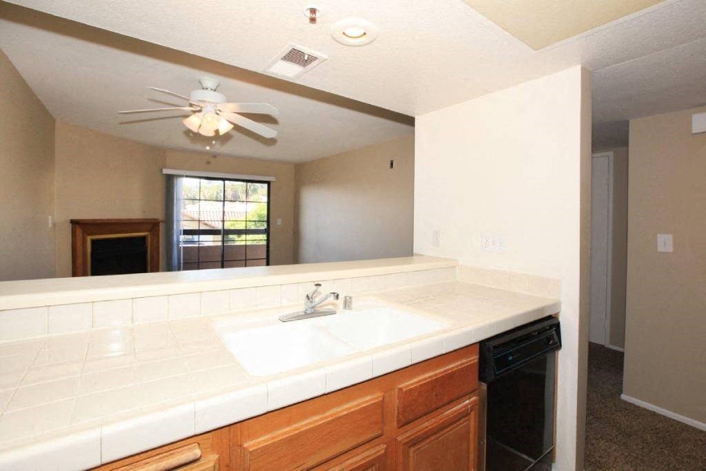 a kitchen with a sink and a ceiling fan