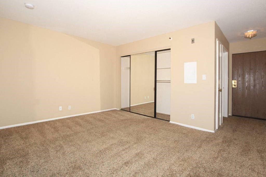 an empty living room with a door to a closet