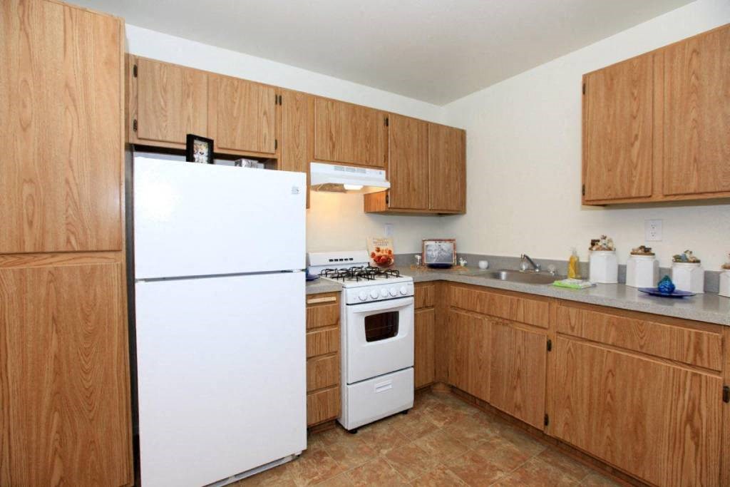 a kitchen with white appliances and wooden cabinets