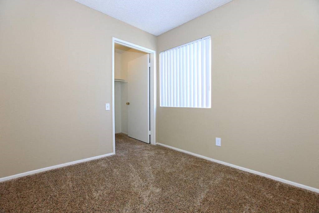 an empty room with a window and a door to a closet
