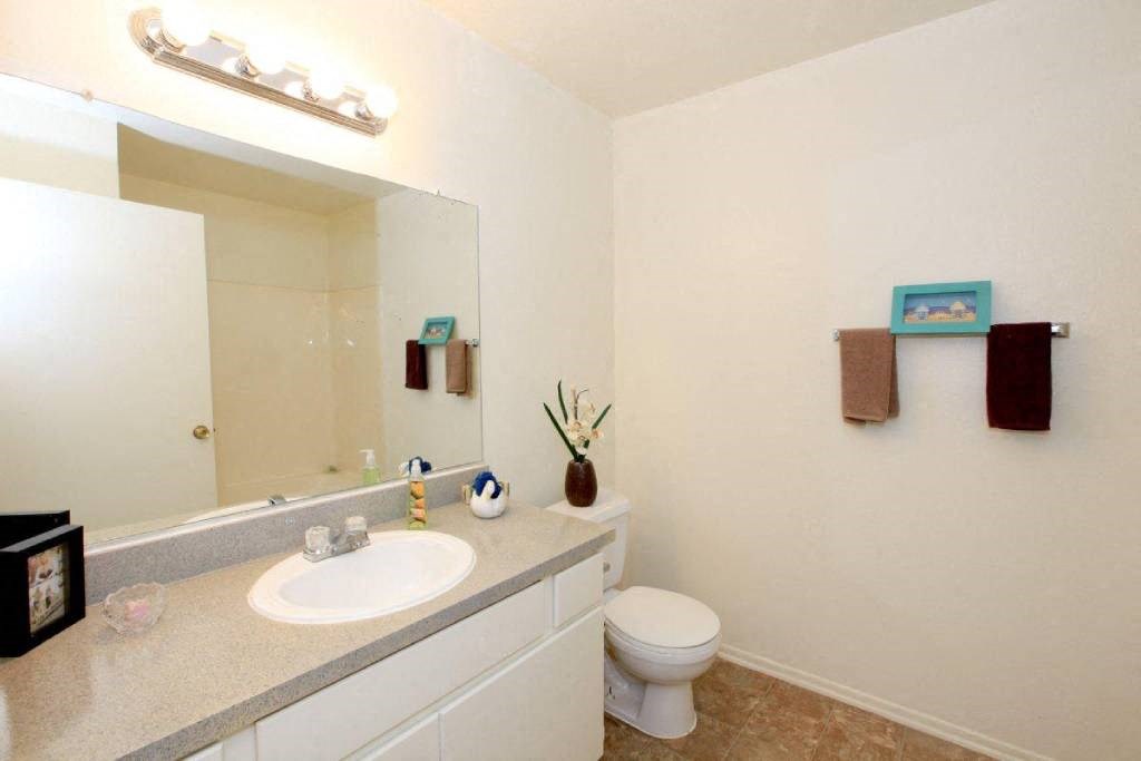 a bathroom with a sink toilet and a mirror