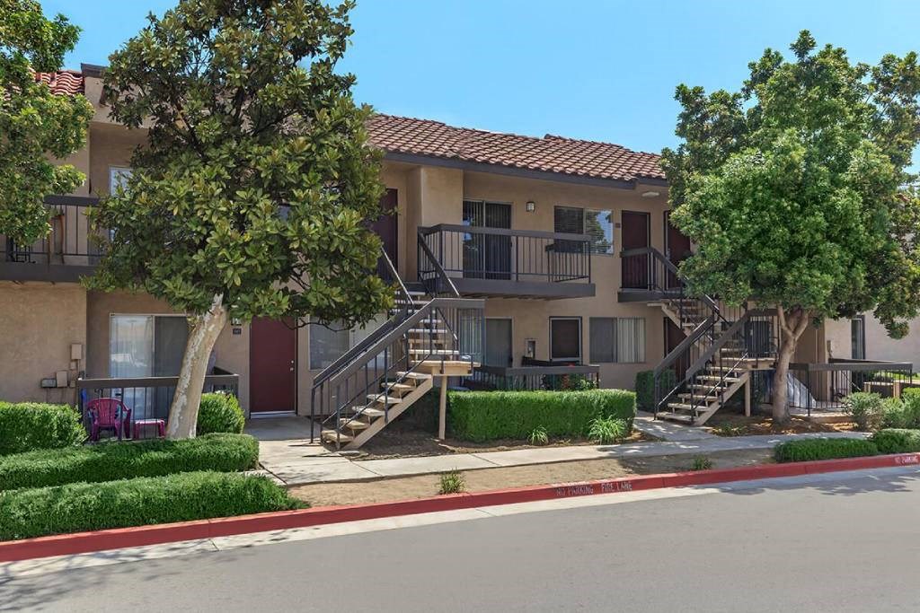 an apartment building with stairs and trees