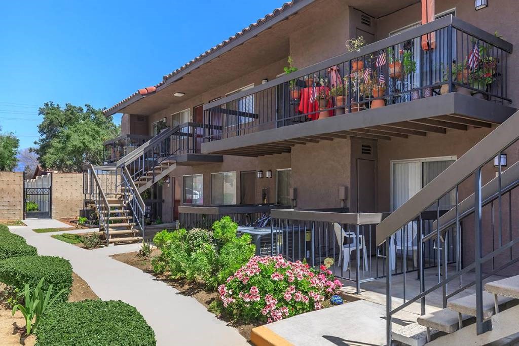 a building with a patio and flowers in front of it