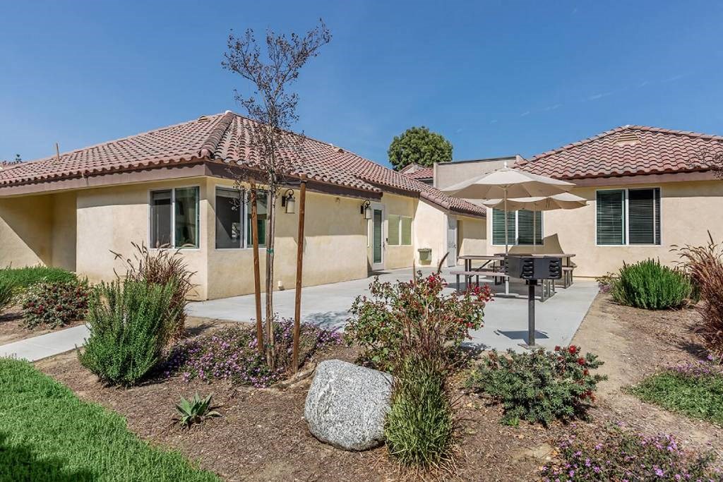 a house with a patio and a table and an umbrella
