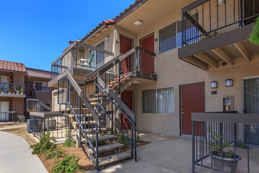 an apartment building with stairs and a balcony