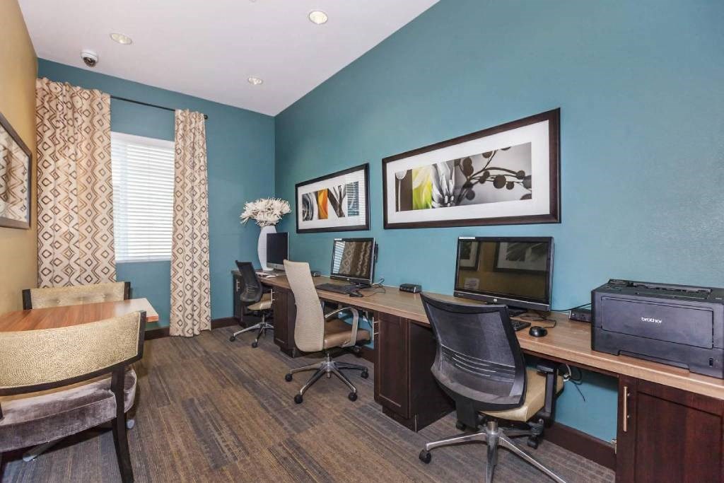 a home office with two desks and a television
