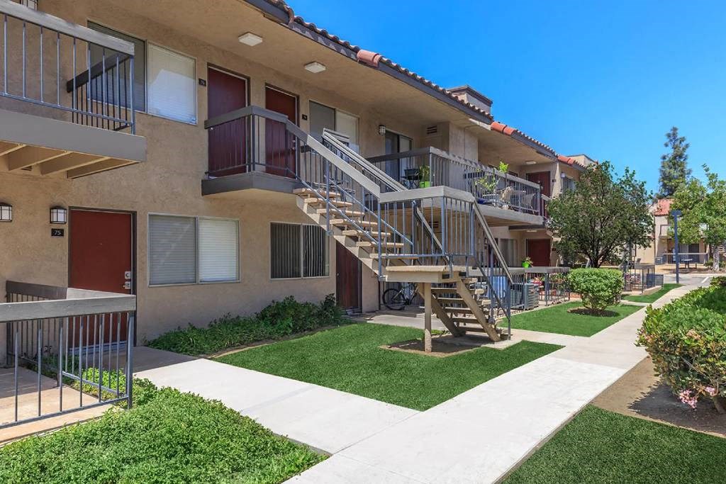 an apartment building with stairs and green grass