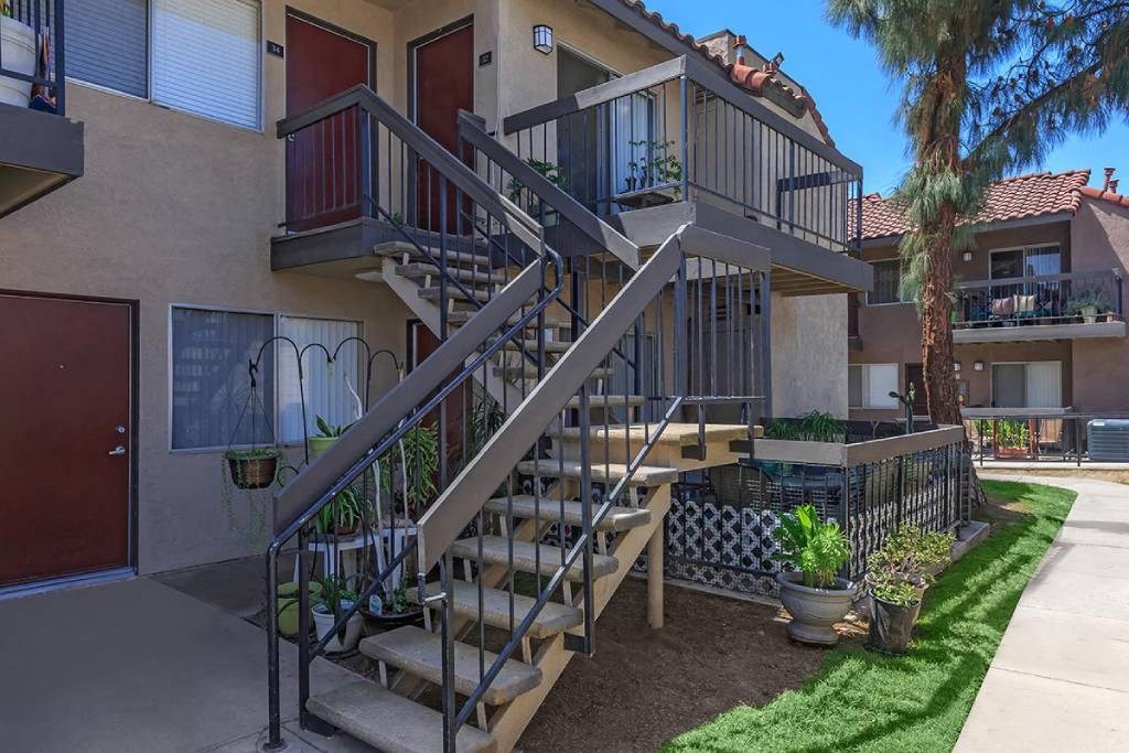 a house with stairs and plants in front of it