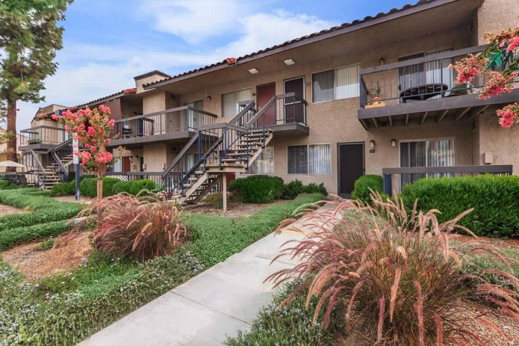 an apartment building with stairs and a sidewalk