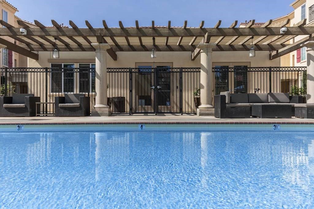 a swimming pool in front of a house with a pool