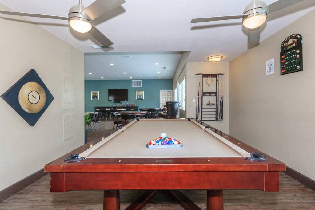 a pool table in a living room with a ceiling fan