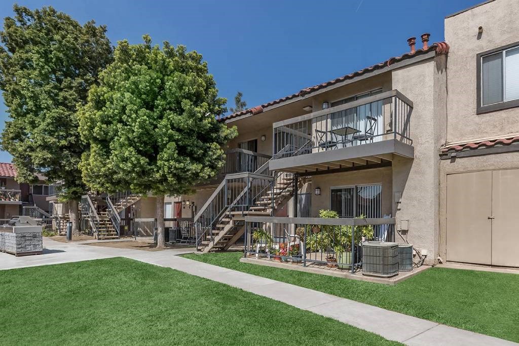 a building with stairs and a tree in the yard