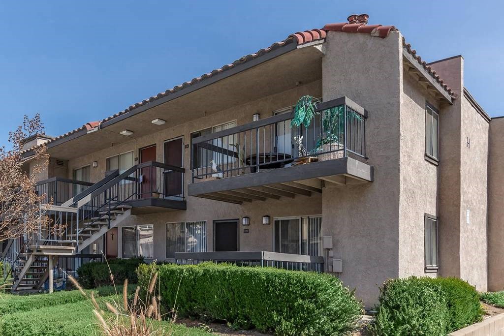 an apartment building with two balconies and a staircase