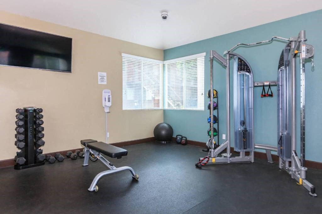 a workout room with weights and a tv