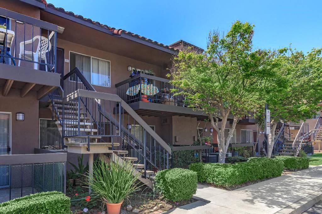 an apartment building with stairs and a sidewalk