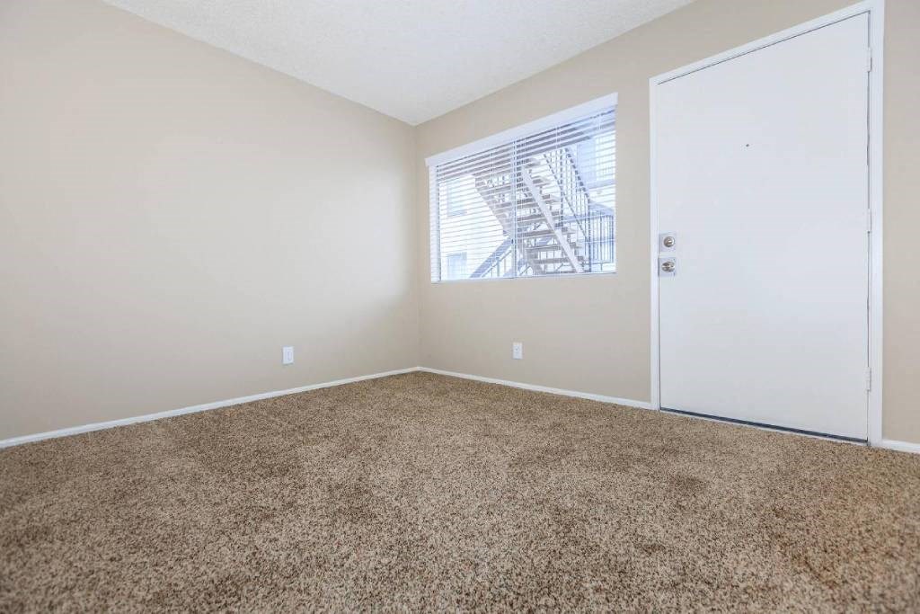 an empty room with carpet and a window