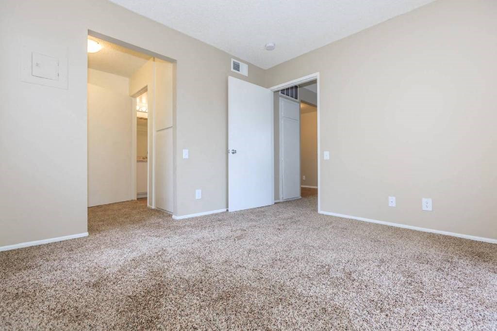 an empty living room with white walls and carpet