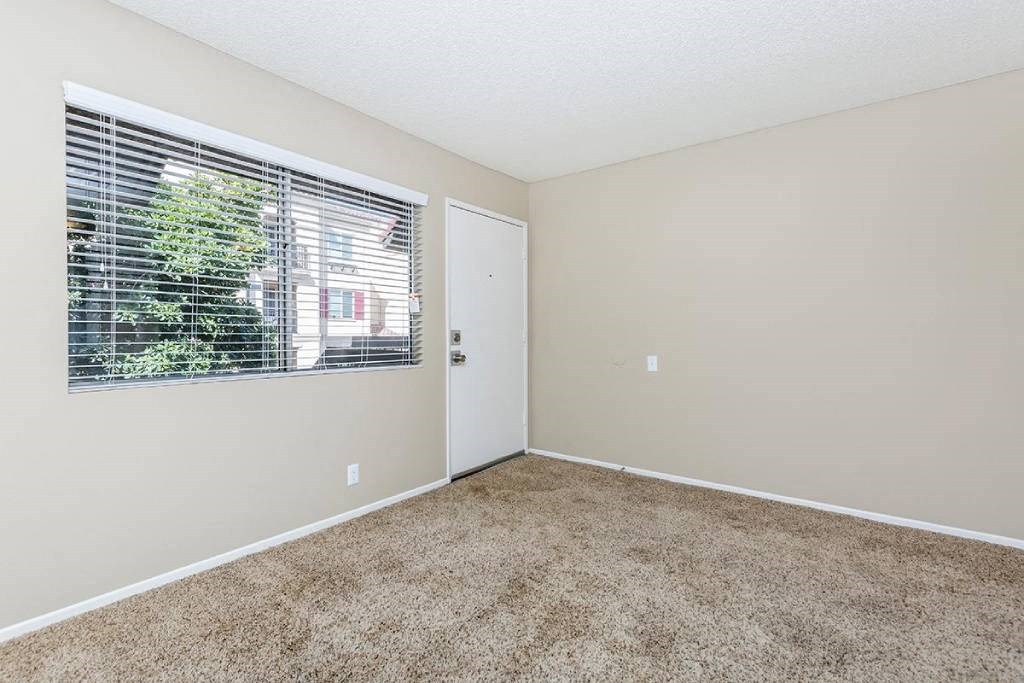 an empty room with a window and a door