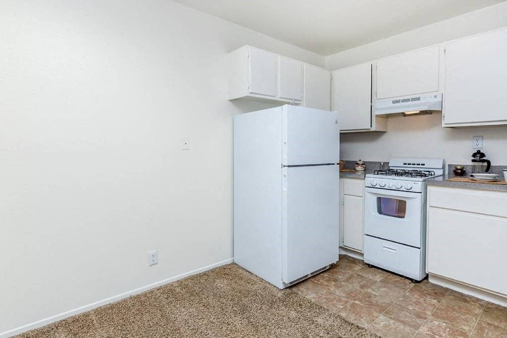 a kitchen with white appliances and white cabinets