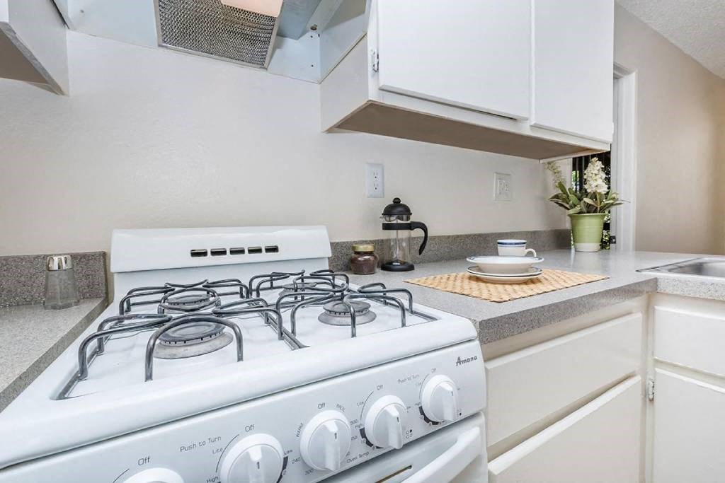 a white stove top oven sitting next to a kitchen counter