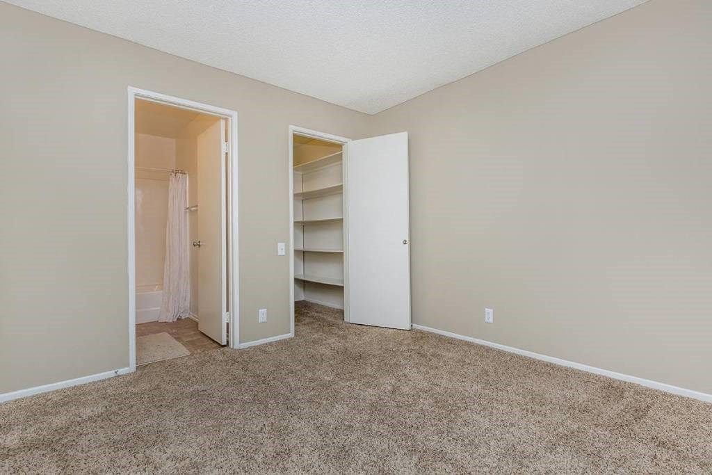 an empty bedroom with a closet and a closet door