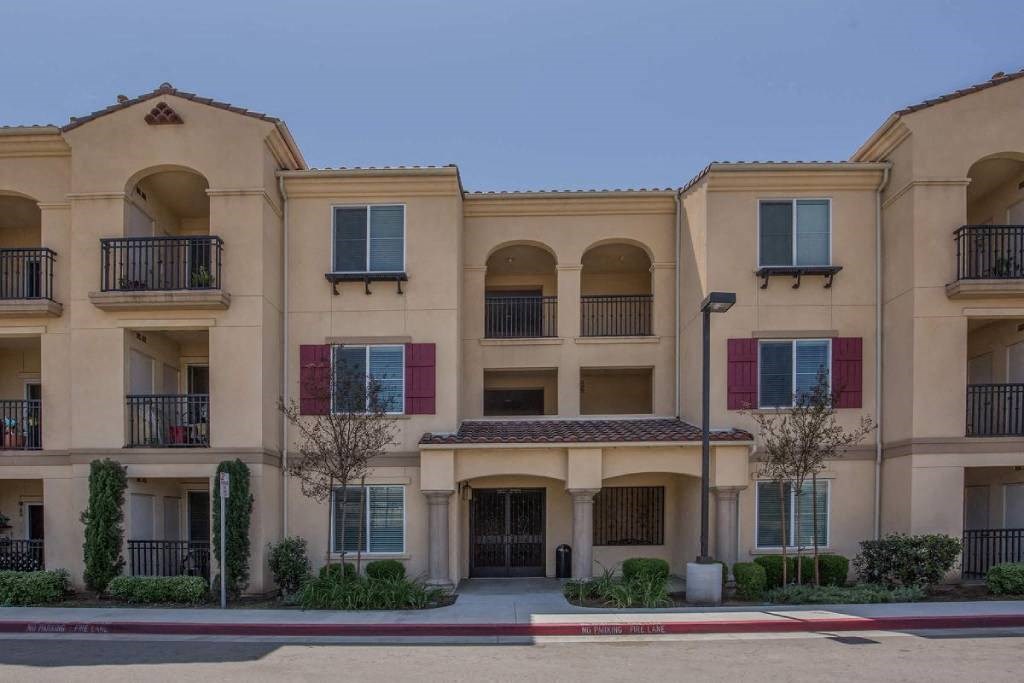 an apartment building with a sidewalk in front of it