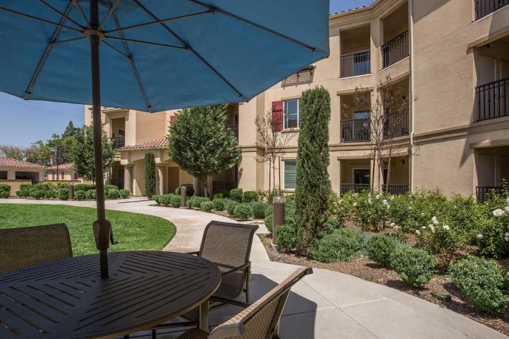 a patio with an umbrella and a table with chairs