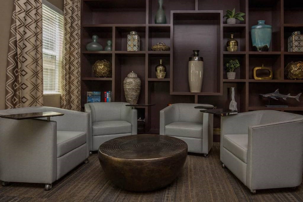 a living room filled with chairs and a table