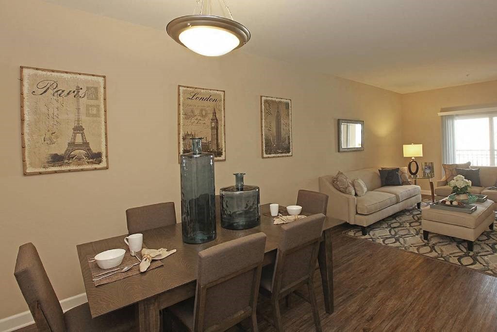 a living room and dining room with a table and chairs