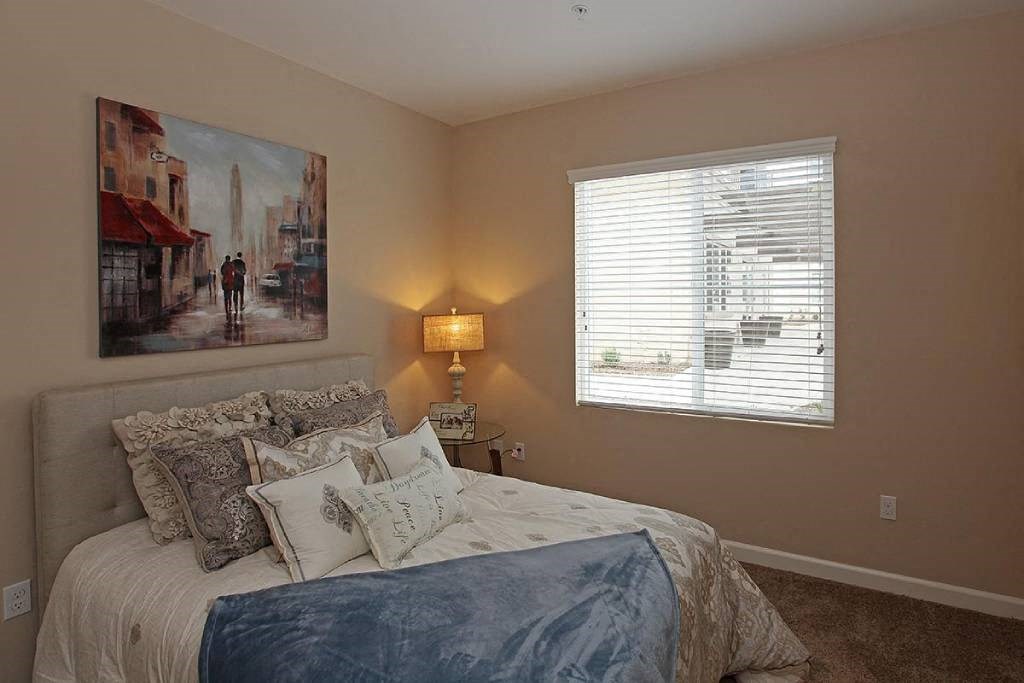 a bedroom with a bed and a painting on the wall