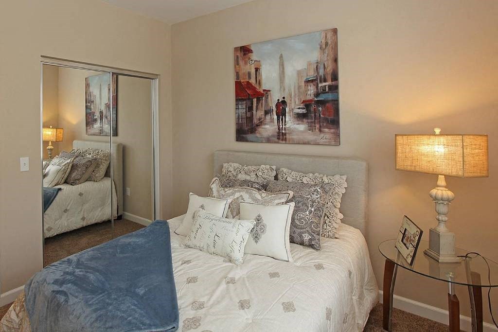 a bedroom with a bed and a painting on the wall