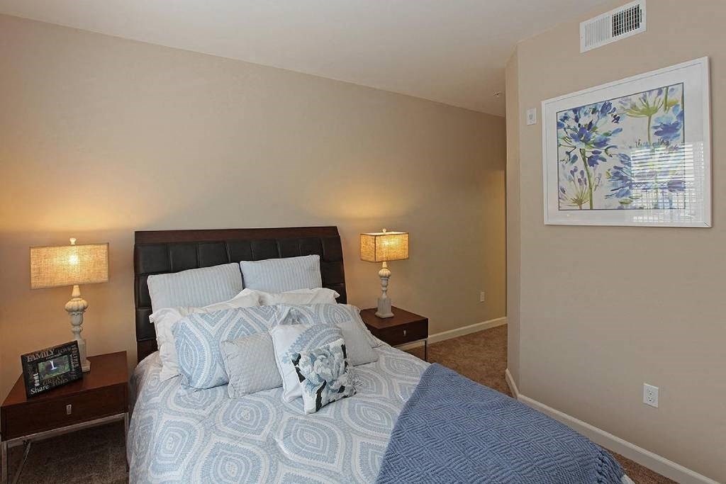 a bedroom with a bed and two lamps