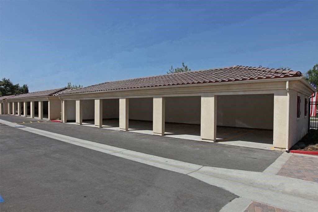 an empty parking lot with a building with pillars