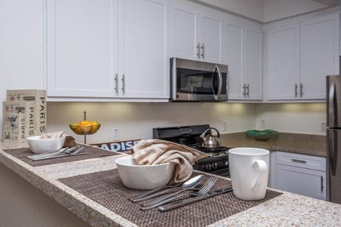 a kitchen with white cabinets and a counter top