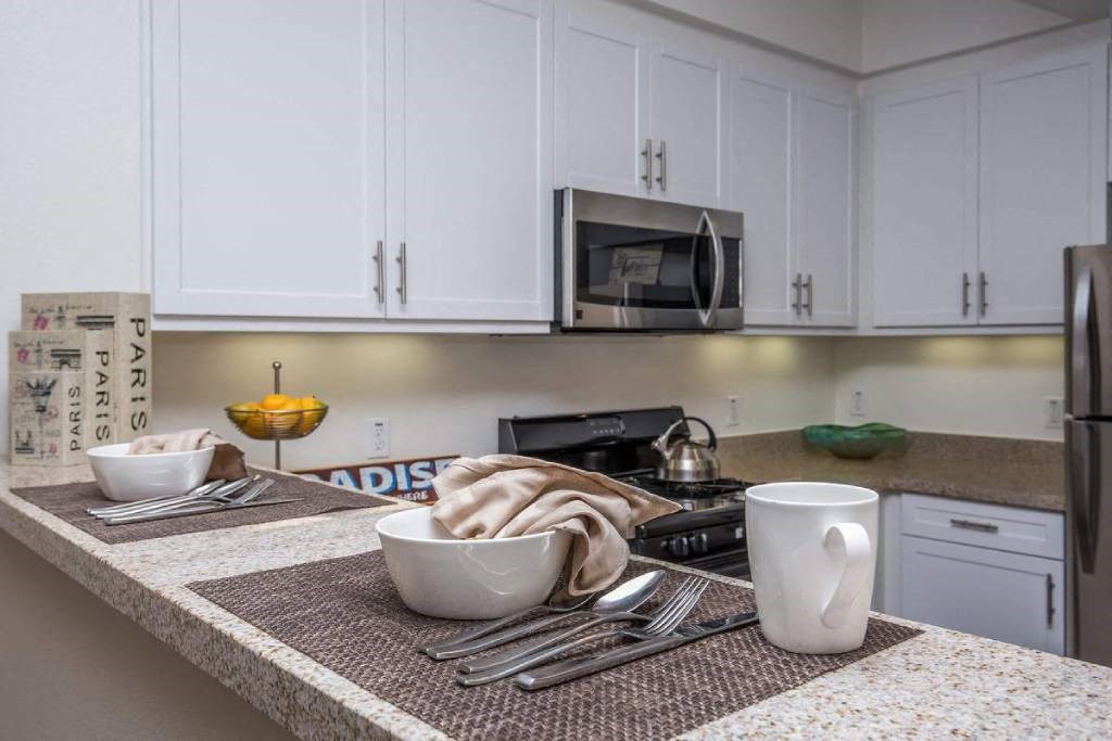 a kitchen with white cabinets and a counter top