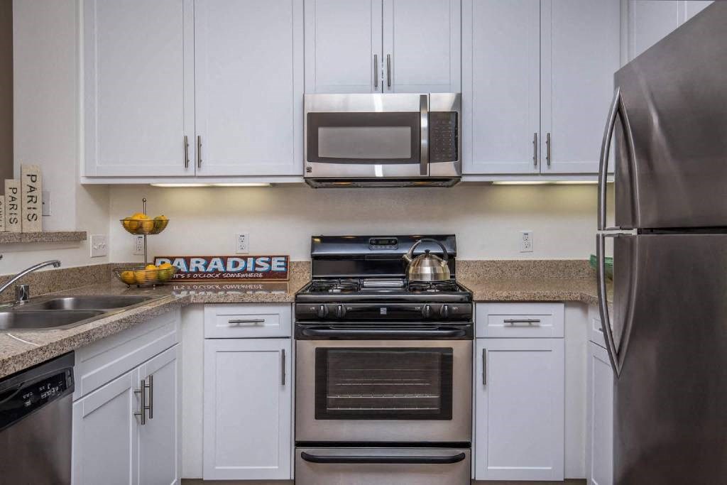 a kitchen with stainless steel appliances and white cabinets