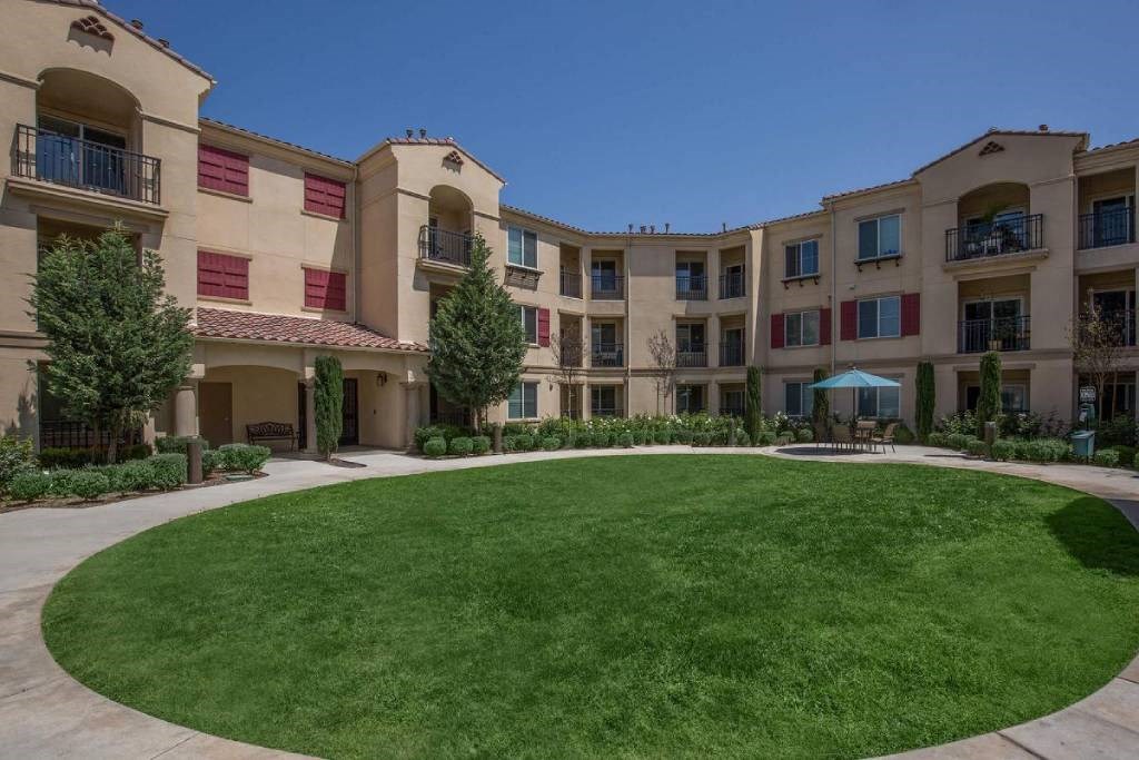 a large green lawn in front of an apartment building
