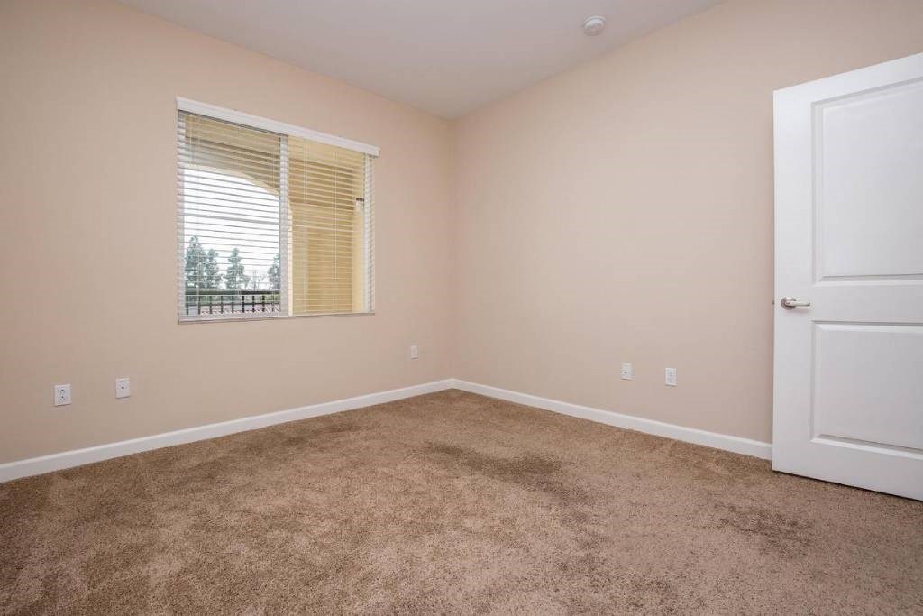 a carpeted room with a window and a door