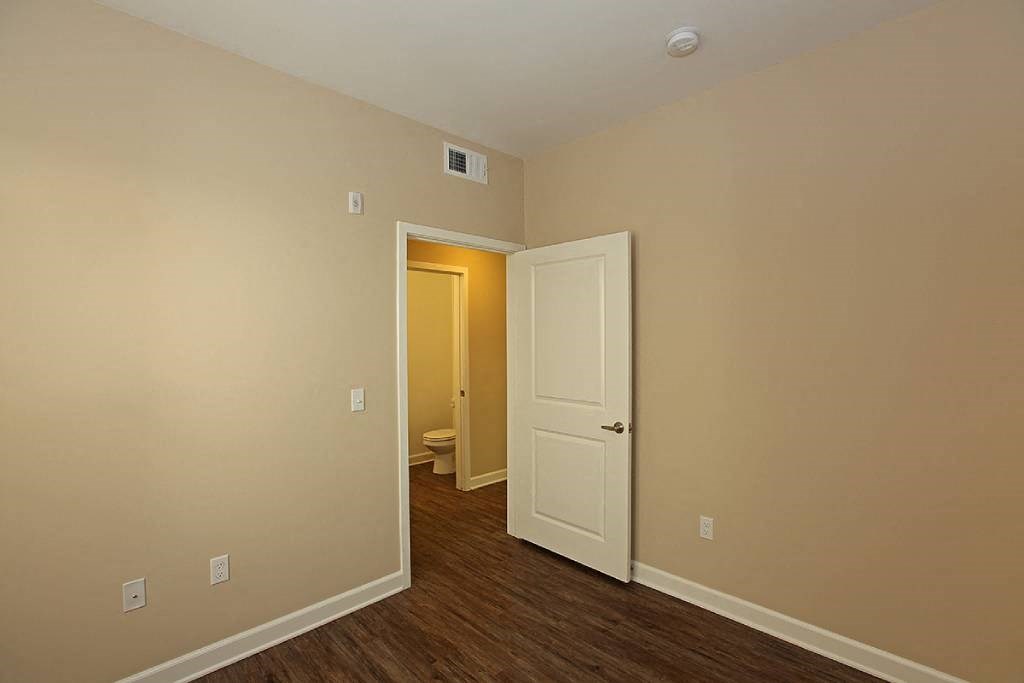 an empty room with a door open to a bathroom