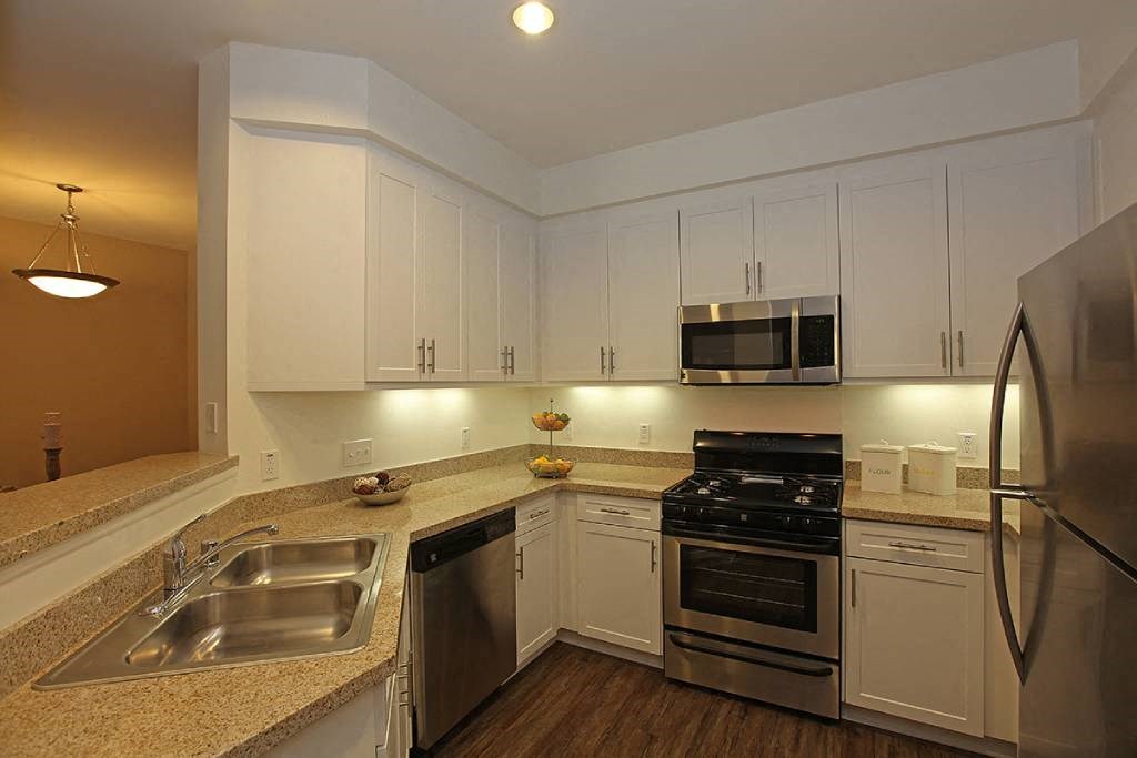 a kitchen with stainless steel appliances and white cabinets