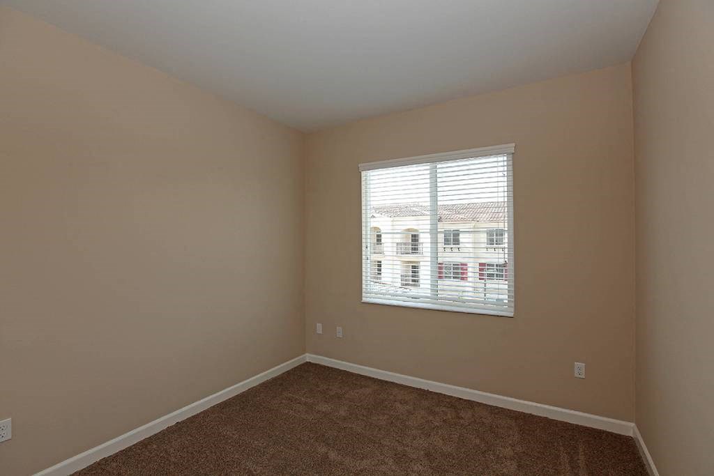 an empty room with a window and a carpet