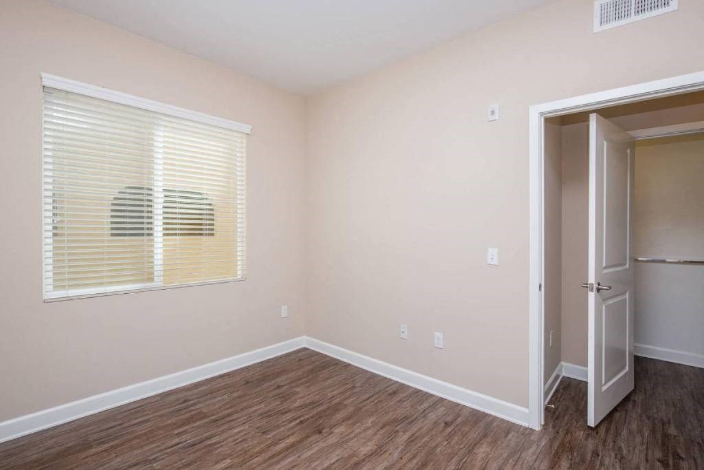 a bedroom with a large window and a door to a closet