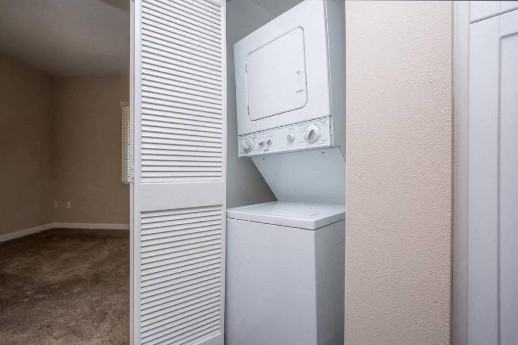 a white washer and dryer in a white closet