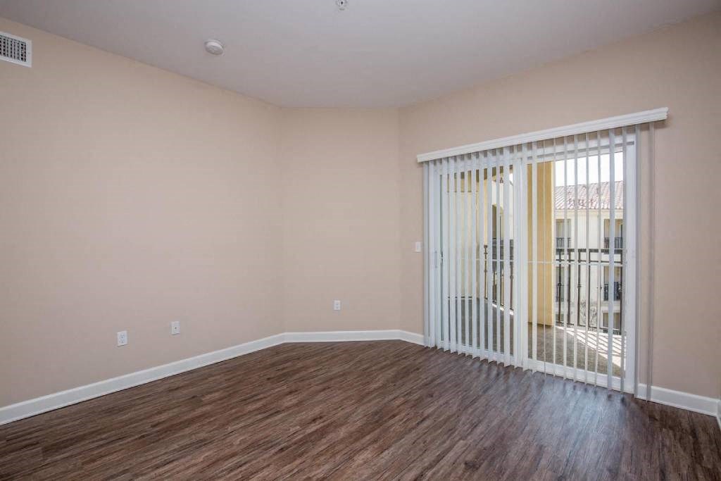 a living room with a sliding glass door and wood flooring