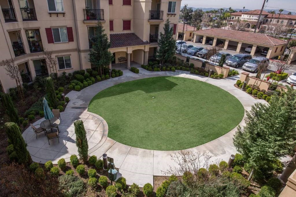 an aerial view of a green circle in the middle of an apartment complex