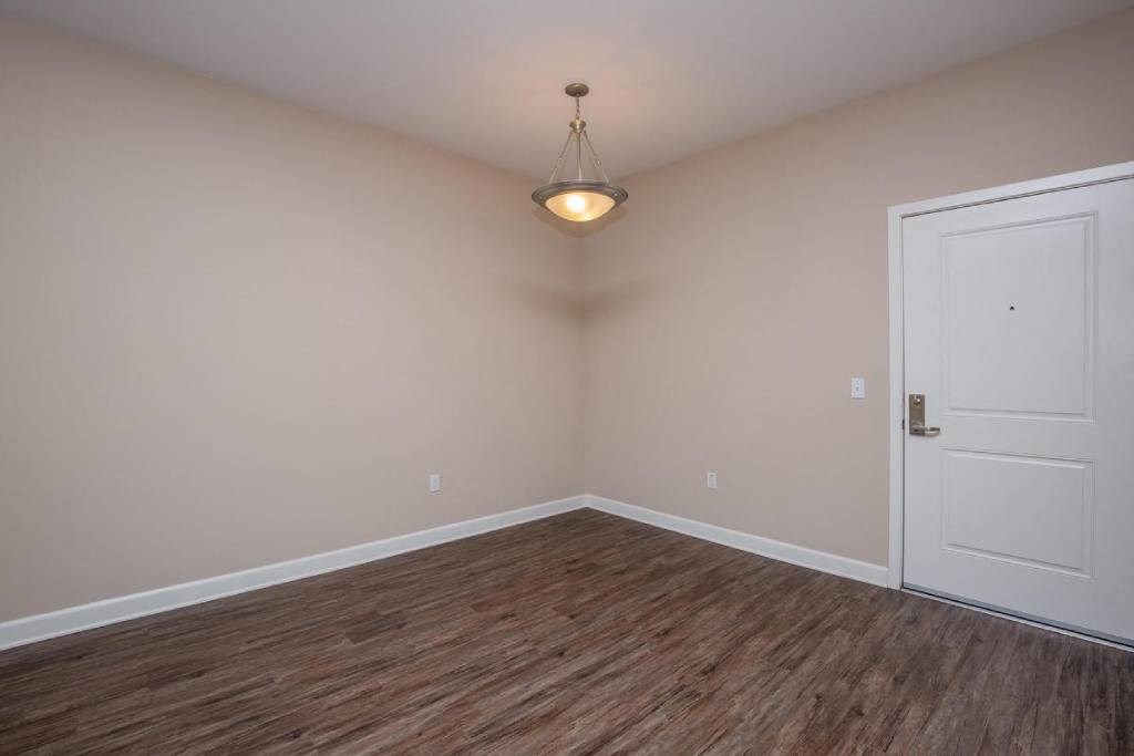 an empty room with a door and a ceiling light