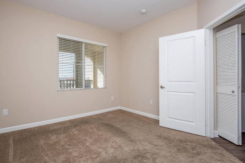a bedroom with a white door and a window