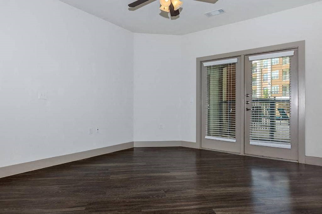 an empty room with a window and a ceiling fan